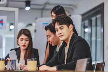 Group of millennial Asian young professional successful male businessmen and female businesswomen in formal suit sitting standing smiling screaming shouting holding fists up celebrating together