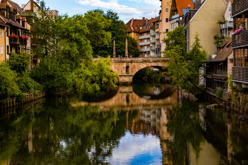 Fototapeta na wymiar A bridge across the river between the houses