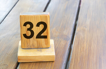 Wooden priority number 32 on a plank tab