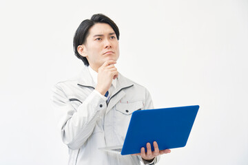 白背景でノートパソコンを持って考える作業員