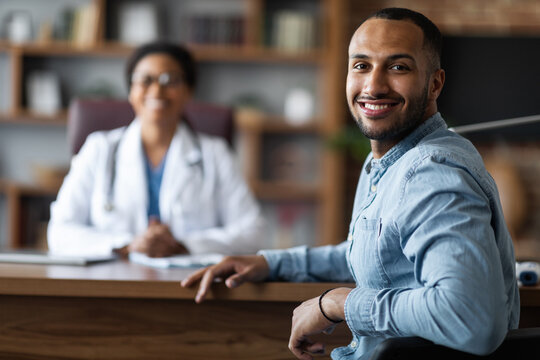 Handsome middle eastern young man having appointment with doctor