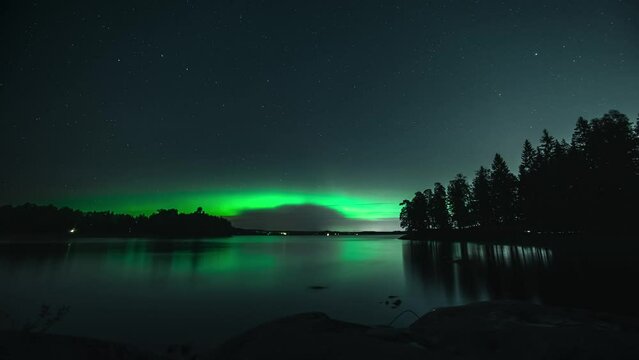 Time-lapse of Aurora borealis dancing and sparkling over a lake, fall in Finland