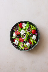 Greek salad with feta cheese, tomatoes, cucumbers, peppers and Kalamata olives. Healthy eating. Vegetarian food.