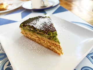 piece of pistachio cake plated in a restaurant