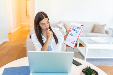 Focused businesswoman presenting charts and graphs on video call online. Young business woman having conference call with client on laptop. Closeup business woman working laptop computer indoor.