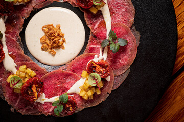 Meat carpaccio on the black plate
