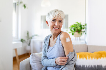 Adhesive bandage on arm after injection vaccine or medicine,ADHESIVE BANDAGES PLASTER - Medical Equipment,Soft focus Adhesive bandage on a female brachium after covid-19 vaccination