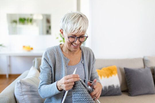 Grandmother Holding Needles Make Repetitive Motion Knitting Sitting On Couch Creating Something With Her Arms. Hand Knitting Improve Brain Function, Older Generation Hobby Concept