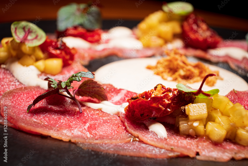 Sticker meat carpaccio on the black plate