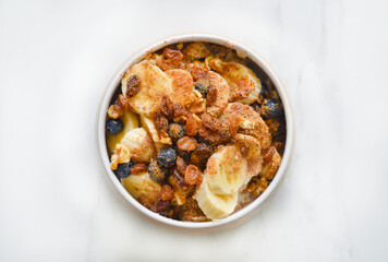 A bowl with the oatmeal, bananas and nuts with the selective focus.