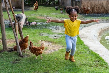 Mix black african kid running happily at an animal farm