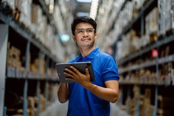 Warehouse Worker using digital tablets to check the stock inventory on the shelf in large...