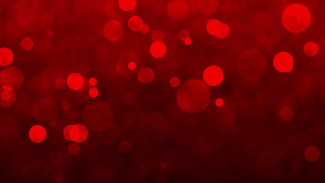 Red animated background with light particles across the screen. Lens focus on red background animation for christmas. Faded red particles glowing on the screen