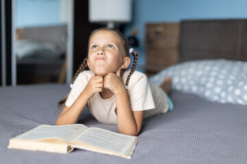 Girl child reads a book in the room