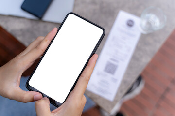 A woman using a smartphone for financial transactions. Hold a phone with a blank screen in your hand. Mobile phone payment