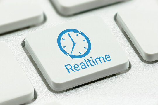 Online payroll payment services and online vendor payment, business concept : Clock logo with the word REALTIME printed on a computer keyboard button, depicting an instant money transfer to a receiver