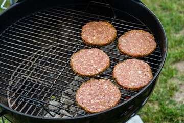 Selective focus of fresh delicious burger cutlets grilling on bbq grill