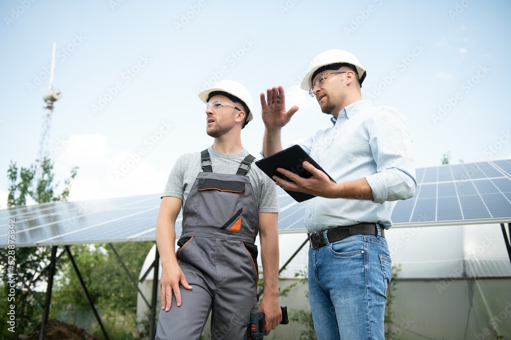 Wall mural near the solar panels, the employee shows the work plan to the boss.