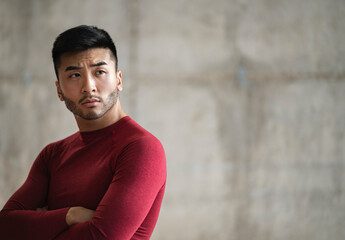 Obraz premium handsome young asian man wearing sportswear, copy space with wall background