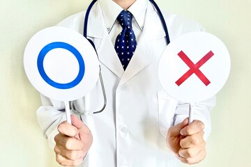 丸とバツをもつ男性医者 判断する