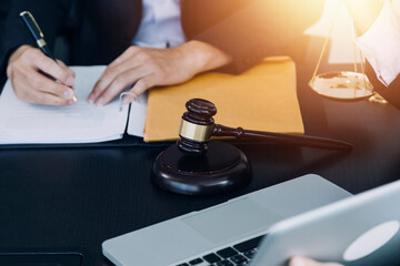 Justice and law concept. Gavel on sounding block in hand's Male judge at a courtroom, working with document law books, report the case on table in modern office.