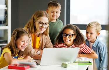 Teacher and pupils using laptop