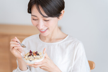 グラノーラを食べるミドル女性（朝食・食事・健康）