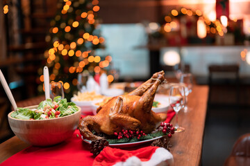 Picture of the dining table at Christmas Buddha amulet with lots of food, turkey, white, Christmas tree and lights.