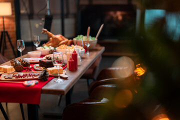 Picture of the dining table at Christmas Buddha amulet with lots of food, turkey, white, Christmas tree and lights.