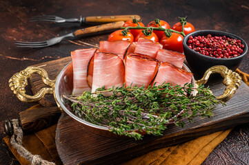 German Black Forest Ham Slices in skillet with thyme. Dark background. Top view