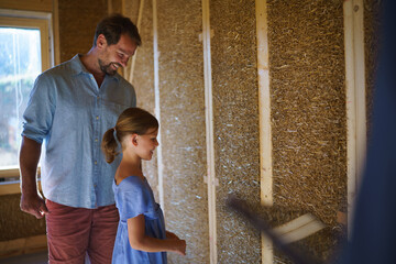 Obraz premium Father with his little daughter checking their unfinished wooden house, diy eco-friendly homes concept.