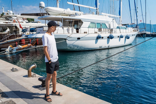 Teenage boy dreams of traveling by sea on sailing ships.