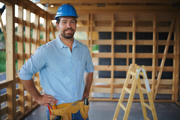 Portrait of construction worker smiling and looking at camera, diy eco-friendly homes concept.