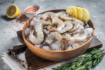 Uncooked Raw peeled tiger white shrimp prawn. Gray background. Top view