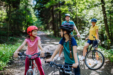 Fototapeta na wymiar Young family with little children at bike trip together in nature.
