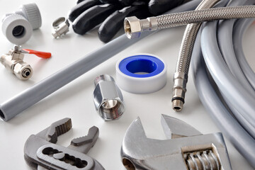 Group of plumbing materials and tools on white workbench elevated