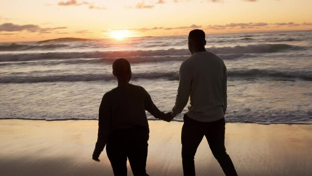 Ocean sunset, couple walking and beach water at night. Black woman, happy african man and love holding hands at sea vacation. Travel together, honeymoon silhouette and evening holiday sky sunlight
