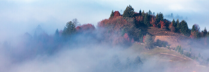 Autumn morning mountain landscape. Sunrise over the fog.