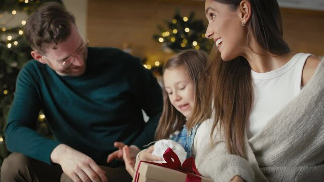 Caucasian family opening Christmas presents at home. Shot with RED helium camera in 8K. 