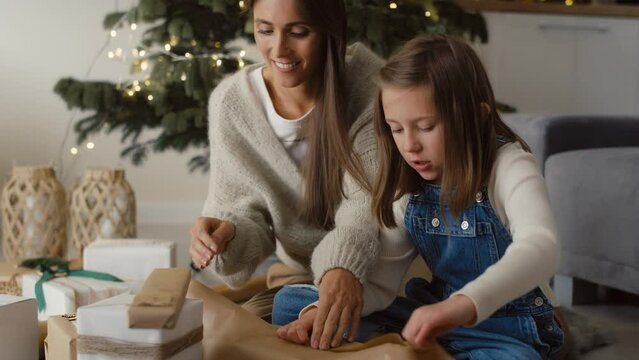 Happy caucasian family packing Christmas gifts together on floor. Shot with RED helium camera in 8K. 