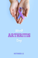World Arthritis Day. Adult hands holding blue purple ribbon on blue background. Rheumatoid arthritis illness disease.