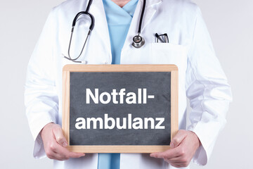 Arzt mit einer Tafel auf der Notfall-Ambulanz steht