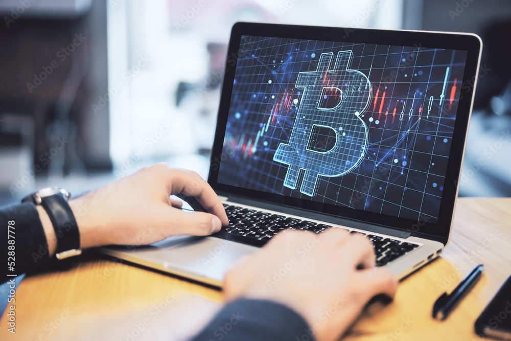 Leinwandbilder close up of businessman hands using notebook with glowing digital bitcoin hologram and lines on blur