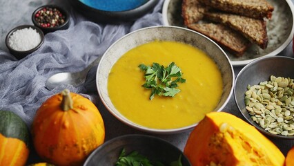 Pumpkin puree isoup in bowl over rusty stone background. Healthy diet food concept