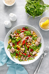 Canned tuna salad with arugula and fresh vegetables, top view