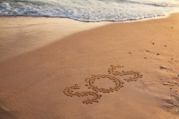 SOS message drawn on sandy beach near sea