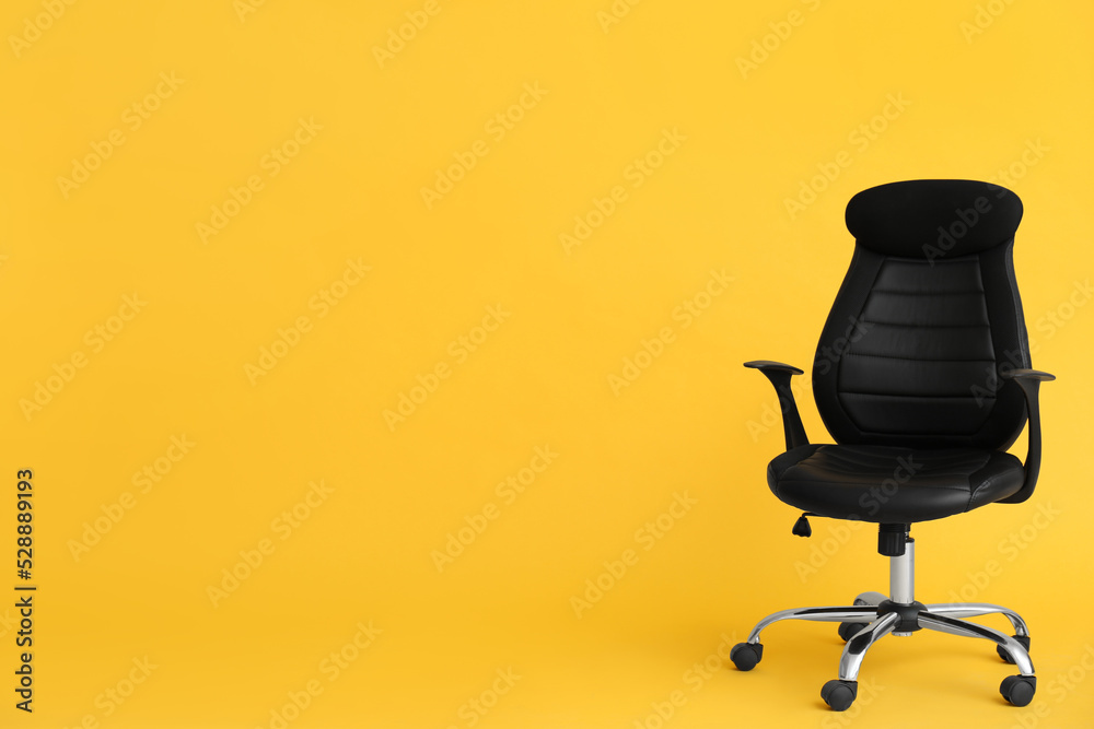 Wall mural modern office chair on yellow background. space for text