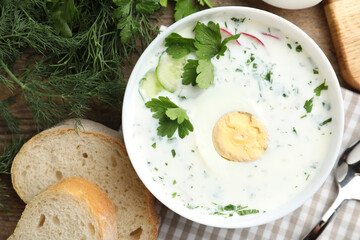 Delicious cold summer soup with kefir served on wooden table, flat lay