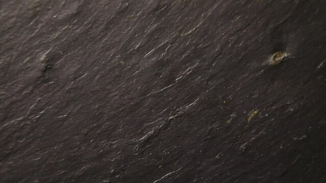 Dark black slate background or texture, rotation. Texture of slate