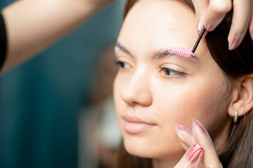 People. Beauty and health. Eyebrow flexing. The make-up artist corrects the eyebrows of a young...